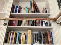 Three shelves filled with books covering diverse subjects: literature, medical, history, and sociology. The books are all lined upright on shelves with easy visibility of titles.