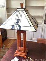 Full view of lamp showing stained glass shade and wooden base