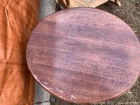 Top view of round wooden coffee table showing surface wear and scratches.