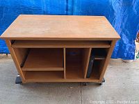 Front angle view of wooden computer desk showing compartments and disk holder on right side