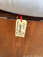 Close-up of handwritten tag identifying the item as a down king size mattress pad