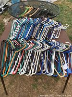 Top-down view of a large assortment of plastic hangers in various colors and styles spread out on a table.