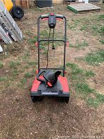 Front view of red and black Power Smart electric snowblower showing chute and controls on handlebar