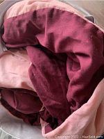 Close-up showing the folded comforter with dark red and pink fabric textures.