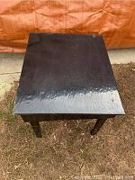 Top view of black swivel table top, showing some surface wear and glossy finish.