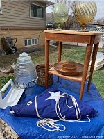 Full scene showing water dispenser, end table, wooden tray, large folded flag, and two decorative large glass goblets on the table.