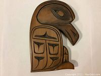 Front view of the wooden raven carving showing detailed engraving and natural wood finish.