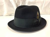 Side view of the black felt Stetson fedora hat showing the bow, feathers, and the classic pinched crown and curled brim.