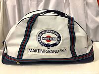 Front view of white textured vinyl Martini gym bag with club logo and Martini Grand Prix text, showing striped blue and red handles and base.