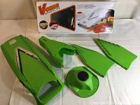 Green Borner V Power Mandoline Slicer base with four green blade attachments and hand guard laid out, original box behind.