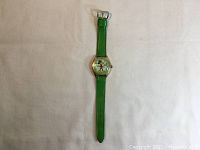 Full view of the green band wristwatch showing the entire watch and strap.