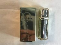 Photo of the serum bottle and reflective silver box from front, showing branding and volume.