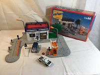 Photo showing full assembled police station set with base roads, police car, figurines, signs, and packaging