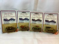 Four vintage die-cast metal Matrice classic car models in original blister packaging shown together.