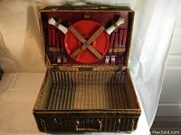 Wide view of open vintage wicker picnic basket showing interior and cutlery storage