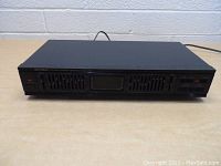 Front view of the Optimus stereo equalizer showing sliders, power button, and display area.