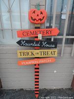 Front view of large Halloween yard sign with pumpkin top and directional arrows.
