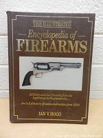 Front cover of The Illustrated Encyclopedia of Firearms book showing text and image of a vintage revolver.