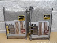 Two packages of Insola energy efficient room darkening curtains, one labeled 95in length and one labeled 84in length, sealed in plastic.