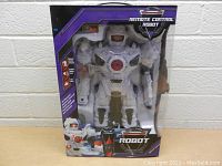 Front view of the white remote control robot toy in original packaging showing packaging design and robot details.