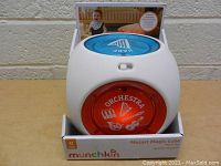 Front view of white cube toy with red circular Orchestra panel and blue panel on top, in display packaging