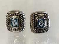 Front view showing pair of square-shaped Judith Ripka sterling silver earrings with blue rectangular stones and rope-style detailing.