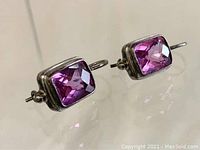 Front view of pair of sterling silver earrings with pink rectangular stones set in silver, showing faceted detail and hoop back closure