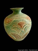 Mid Century terra cotta pot against a black background showing the citrus and leaf pattern and overall shape.