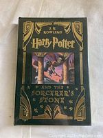 Front cover of the Collector's Edition Harry Potter and the Sorcerer's Stone showing detailed gold foil embossed designs and a color illustration in the center.
