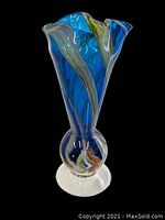 Blue swirl art glass vase against a black background showing shape and swirl details.