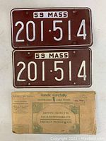 Front view of two 1959 Massachusetts license plates with registration card envelope below them.
