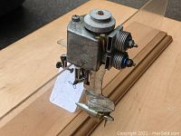 Three-quarter view showing engine block, twin cylinders, top pulley and propeller