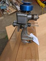 Side profile showing die-cast aluminum body, clamp mount and two-blade propeller.