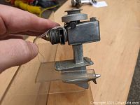 Side view showing the metal motor with propeller and mounting base.