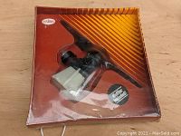 Front view of sealed original packaging showing the engine with attached white fuel tank and muffler included label.