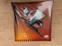 Front view of the sealed Testors .049 model airplane engine in original box with plastic window showing engine inside.