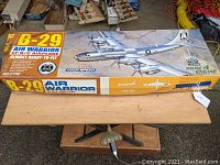 Box top showing B-29 Air Warrior model airplane kit on wooden table.