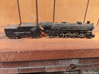 Side view of the black American Flyer 282 4-6-2 locomotive and matching tender showing overall condition with dust and surface rust.