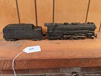 Side view of black Lionel Lines tender and locomotive 2055 on wooden surface