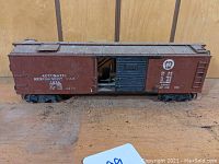 Side view showing brown PRR boxcar with white lettering and sliding door closed.