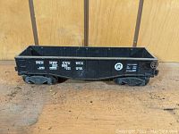 Side view of black Lionel 2452 Pennsylvania gondola car with white detailed markings and Pennsylvania Railroad logo.