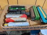 Top view showing box of loose HO scale train locomotives and freight cars