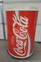 Front view showing Coca-Cola branding and red can design of rolling cooler