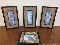 Four framed wild animal prints displayed on a wooden surface: giraffe, lion with cub, zebra (all vertical, 9"x15"), and a smaller square leopard print (9"x11") with leopard print matting