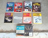 Nine items laid out on floor: multiple auto-related catalogs and manuals, plus a seven-piece auto body repair kit in original packaging.