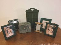 Group photo showing all five picture frames, decorative photo box, and small six-drawer chest arranged on a wooden surface against a plain background