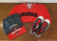Overview photo of red windbreaker, two dri-fit shirts folded, and sneakers.