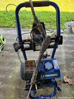 Side angled view of the Powerhorse pressure washer showing the frame, hose, wand, spray gun, and fuel tank.