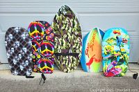 Single image showing all five boards side by side, two skim boards and three boogie boards with distinct colorful designs