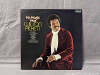 Front cover of the vinyl record album titled 'Mr. Magic Man' by Wilson Pickett showing the artist in a burgundy velvet suit, white cravat against a black background with album title in yellow.